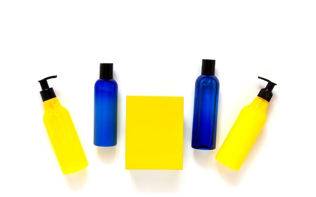 Botellas cosméticas de verano brillantes de azul y amarillo en una vista superior de fondo blanco