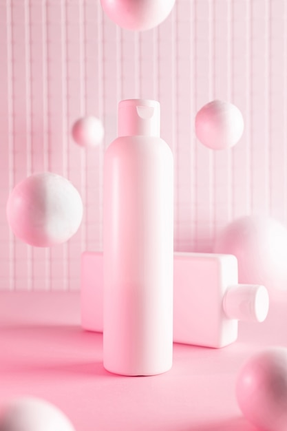 Botellas de cosméticos con bolas voladoras en una luz de neón rosa, maqueta