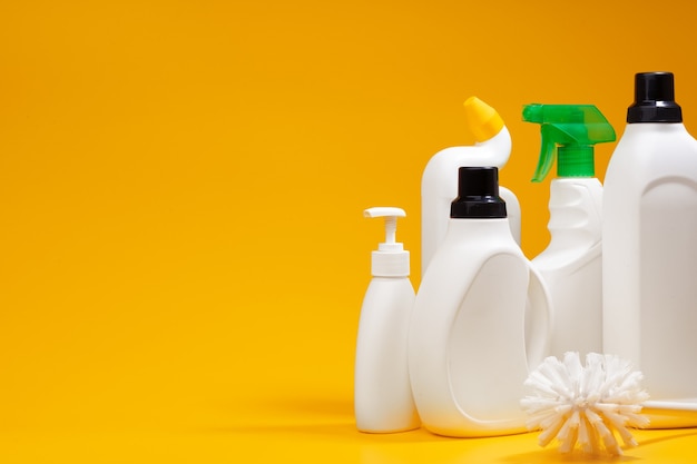 Foto botellas de detergente de limpieza de la casa sobre un fondo amarillo