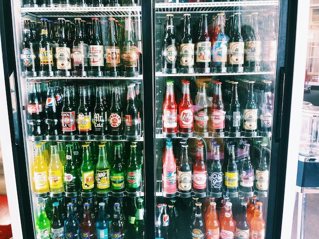 Foto botellas dispuestas en el refrigerador de la tienda para la venta