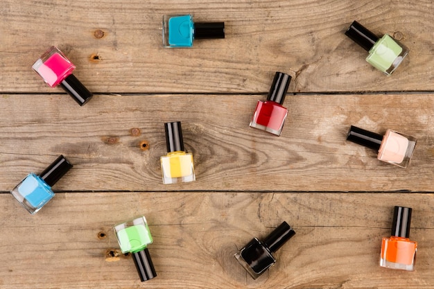 Botellas de esmalte de uñas de colores en la mesa de madera marrón