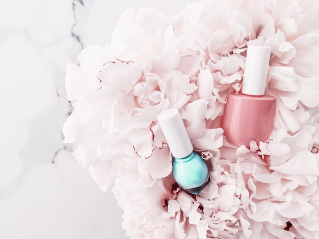 Botellas de esmalte de uñas sobre fondo floral manicura francesa y marca cosmética