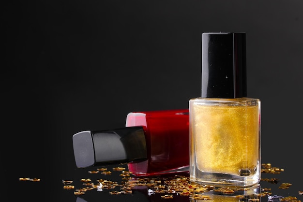 Botellas de esmalte de uñas sobre fondo negro