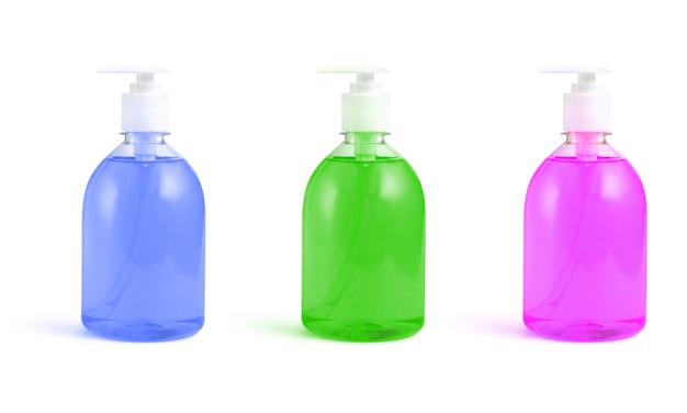 Botellas de jabón líquido rosa, verde y azul sobre un blanco aislado