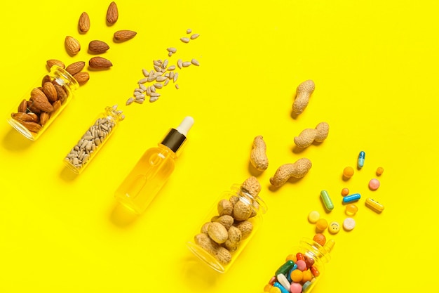 Botellas con nueces saludables, semillas, píldoras y aceite en la superficie de color