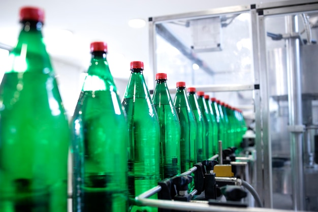 Botellas de plástico en la cinta transportadora que se llena con agua potable