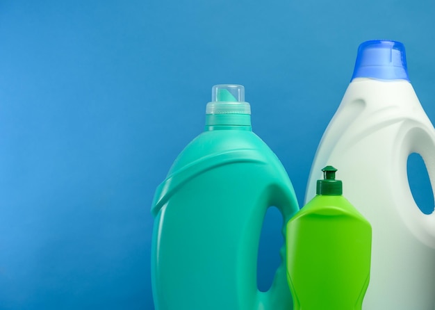 Foto botellas de plástico con detergentes en el fondo azul espacio de copia