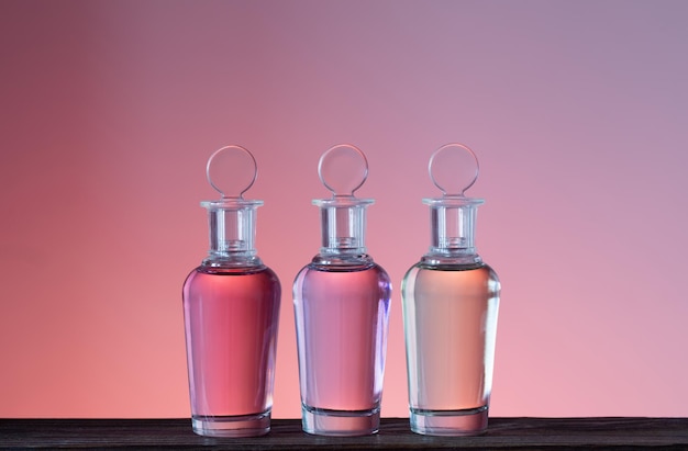 Foto botellas con pociones mágicas sobre fondo rosa.