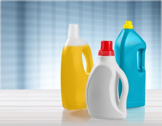 Botellas de productos químicos domésticos en mesa de madera