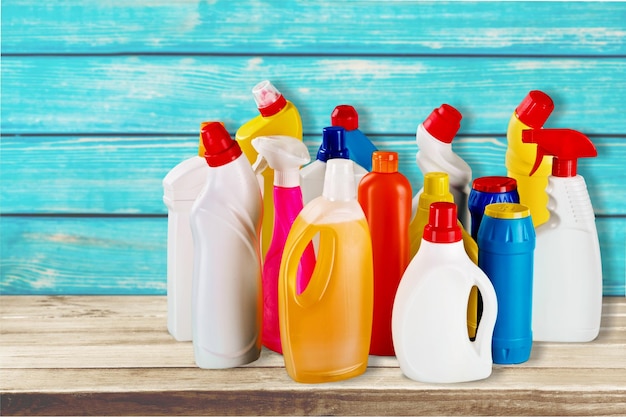 Foto botellas de productos químicos domésticos sobre fondo de madera con etiqueta en blanco