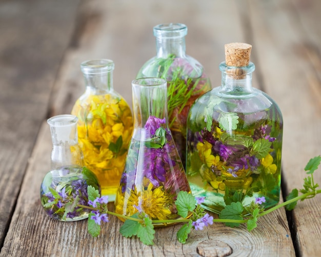 Botellas de tintura o infusión de hierbas saludables en la mesa Medicina herbaria