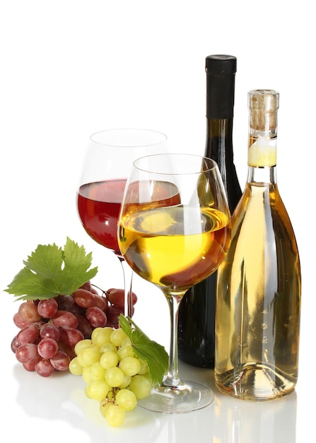Botellas y vasos de vino y uvas maduras aisladas en blanco