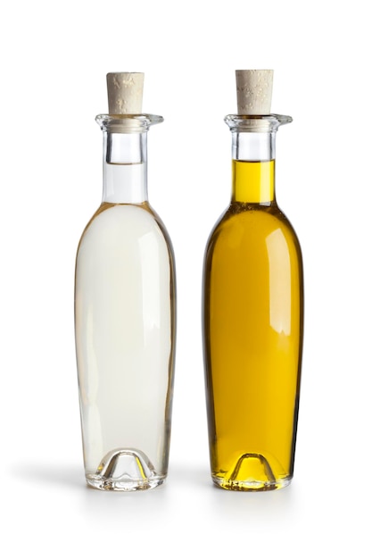Botellas de vidrio con aceite y vinagre aisladas sobre un fondo blanco de cerca