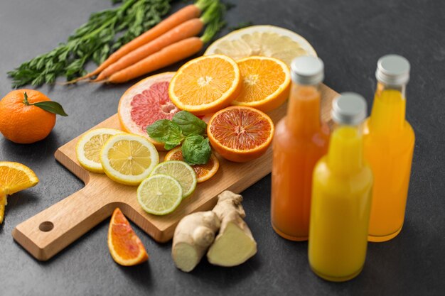 Foto botellas de vidrio de jugo de frutas en la mesa de pizarra