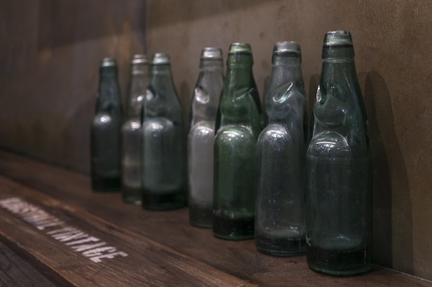 Botellas viejas de la vendimia en el estante adornado en la casa para el estilo retro de la decoración del vintage.