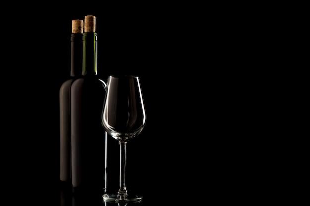 Botellas de vino con corcho y vidrio sobre fondo negro aislado