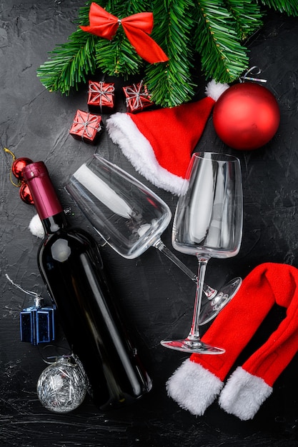 Botellas de vino Feliz Navidad y Feliz Año Nuevo, sobre fondo de mesa de piedra oscura negra, vista superior laicos plana