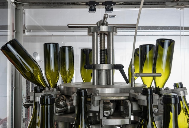 Botellas de vino de Italia Sicilia se lavan y se llenan de vino por una máquina industrial en una fábrica de vino