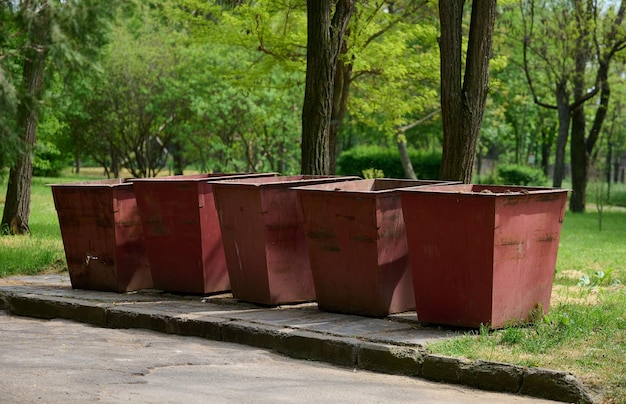Botes de basura de metal vacíos en el parque