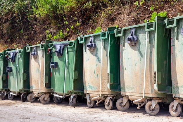 Botes de basura o basura de pie en una fila al aire libre