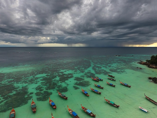 Botes de cola larga en la playa y nubes de tormenta