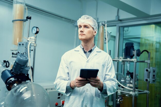 Boticário cientista trabalhando em laboratório para extração de cannabis com tablet