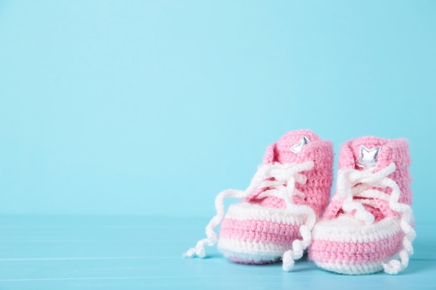 Botinhas de bebé rosa em azul com espaço de cópia