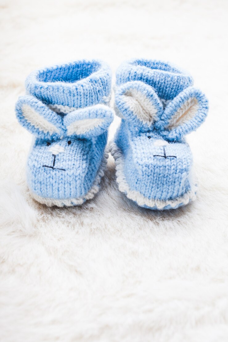 Foto botinhas de tricô azul bebê com focinho de coelho para menino