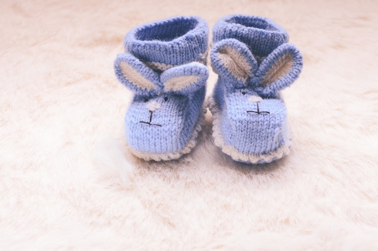 Foto botinhas de tricô azul bebê com focinho de coelho para menino