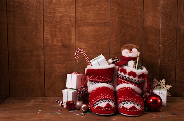 Botitas de punto con regalos navideños y diversos adornos.