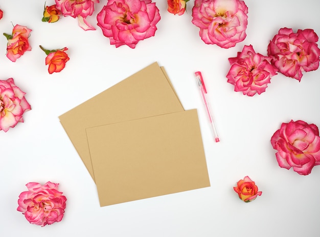 Botões de rosa cor de rosa e um envelope de papel pardo