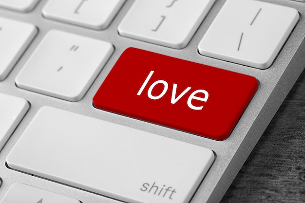 Botón de amor en el primer plano del teclado del portátil Sitio de citas en línea
