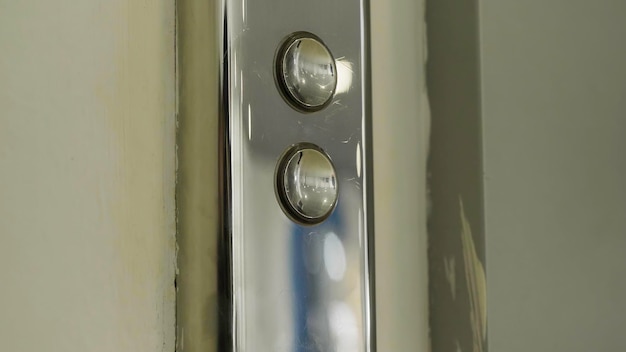 Foto botón del ascensor y una pared beige hdr de botones metálicos de un ascensor público en la tienda