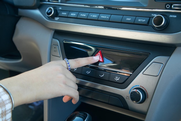 Botón de coche de prensa de mano femenina