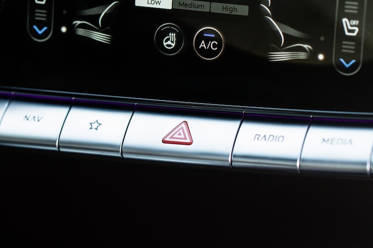 Foto botón de luz de peligro de triángulo rojo en el salpicadero del coche botones multimedia del coche salpicadero detalle de los controladores de un coche moderno