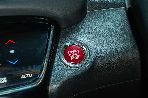 Botón de parada de arranque del motor en el tablero de instrumentos con textura de cuero negro del automóvil moderno