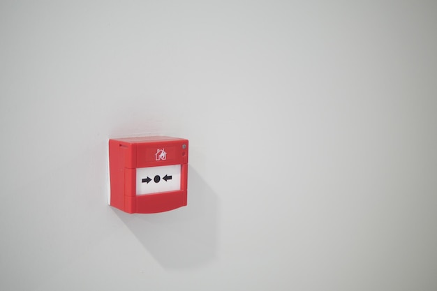 Botón rojo de alarma de incendio en la pared