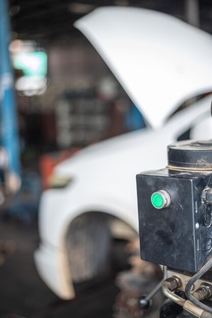 Un botón verde está en una caja negra al lado de un coche blanco