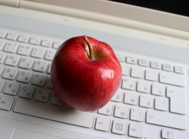 Botones borrosos de teclado blanco con jugosas manzanas rojas en él