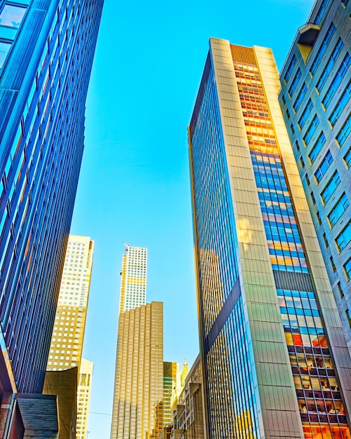 Bottom-up Street View auf Financial District von Lower Manhattan, New York City, NYC, USA. Wolkenkratzer hohe Glasgebäude Vereinigte Staaten von Amerika. Blauer Himmel im Hintergrund. Leerer Platz für Kopienraum.