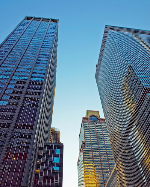 Foto bottom-up street view auf financial district von lower manhattan, new york city, nyc, usa. wolkenkratzer hohe glasgebäude vereinigte staaten von amerika. blauer himmel im hintergrund. leerer platz für kopienraum.