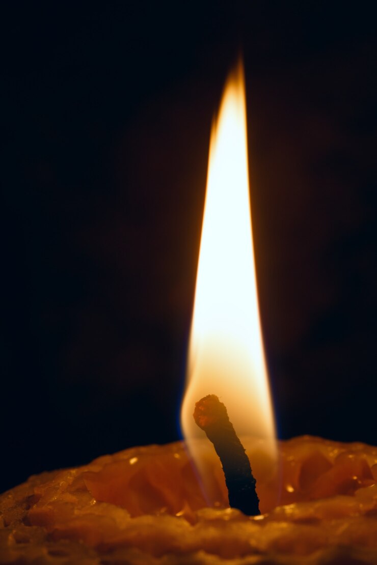Foto bougie iluminado em close up de fundo escuro.