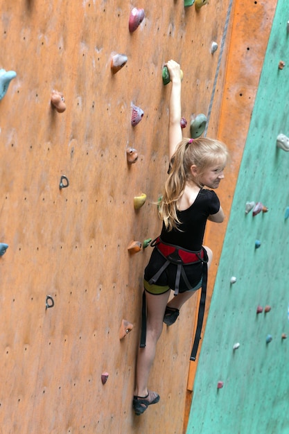 Boulder, niña jugando en el fondo de la pared de escalada