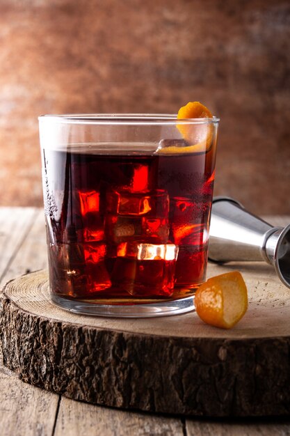 Boulevardier Cocktail und Orangenschale auf Holztisch