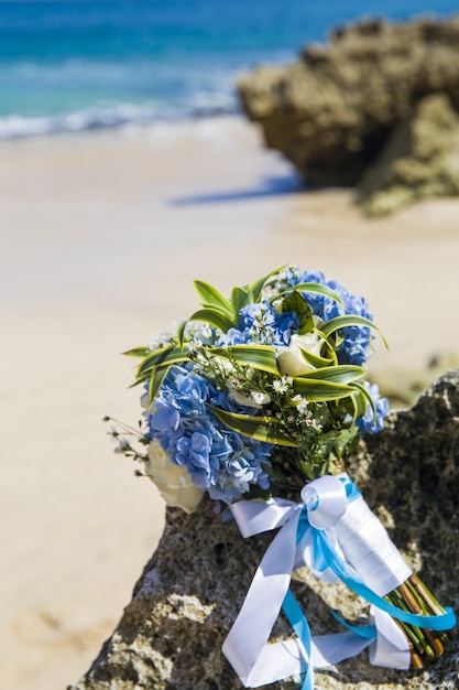 El bouque de boda de la novia está en la playa