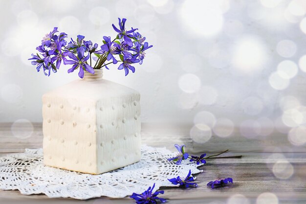 Bouquet de flores azuis de primavera em um espaço de vaso branco para bokeh de texto