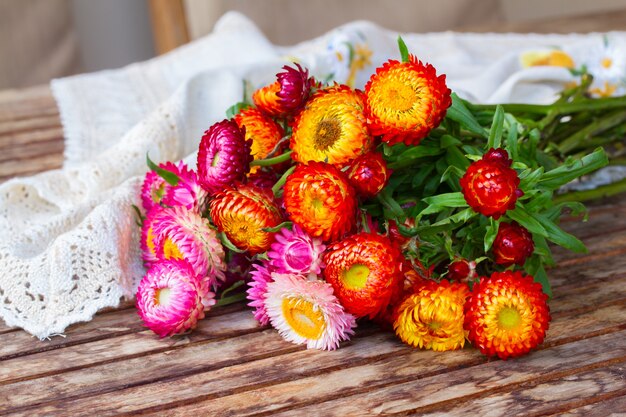 Bouquet de flores frescas da eternidade na mesa de madeira