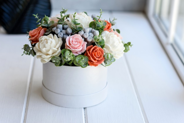 Bouquet de lindas flores rosas brilhantes em caixa de papelão cilíndrica para presente