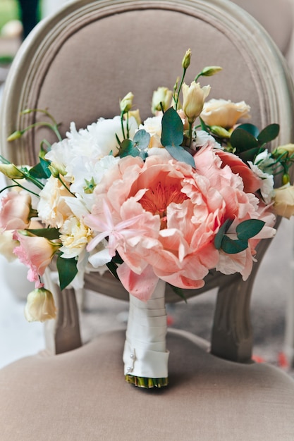 Bouquet de noiva close-up de primavera fresca e flores de verão em tons pastel ficar em uma cadeira clássica