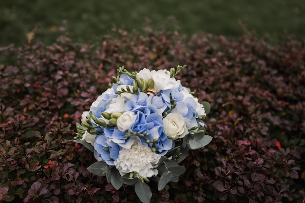 Bouquet de noiva de flores com alianças de ouro